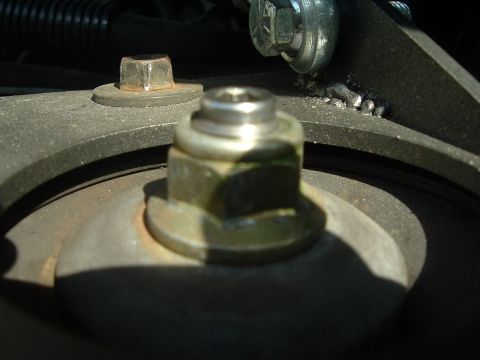 1993 Ford Taurus - A close-up shot focuses on a bolt and nut assembly within the vehicle's suspension system.