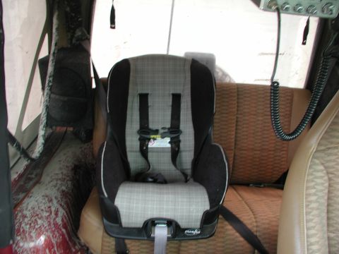 1998 Jeep TJ - A child car seat is secured in the back seat of a vehicle, with the vehicle's interior visible.