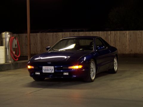 1995 Ford Probe - A dark blue 1995 Ford Probe is parked at a gas station at night, illuminated by artificial lights.