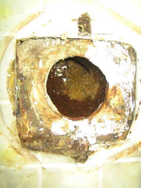 1968 Ford Mustang - Close-up of a heavily rusted metal opening, showing significant corrosion and damage.