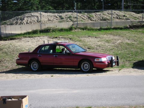 1991 Ford LTD Crown Victoria - This 1991 Ford Crown Victoria LTD, equipped with a light bar and push bumper, is seen from the side.