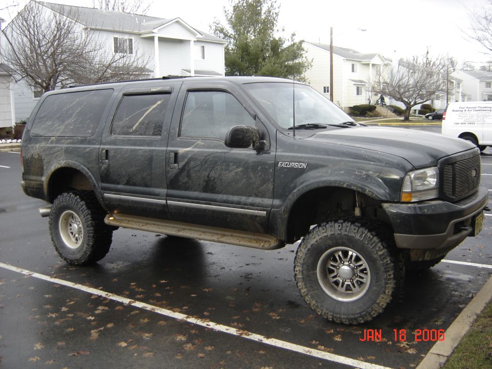 Black lifted 2003 Ford Excursion side view with aftermarket wheels