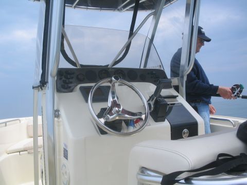 1979 Ford F-250 - A person fishes from a boat, with the helm and dashboard visible.