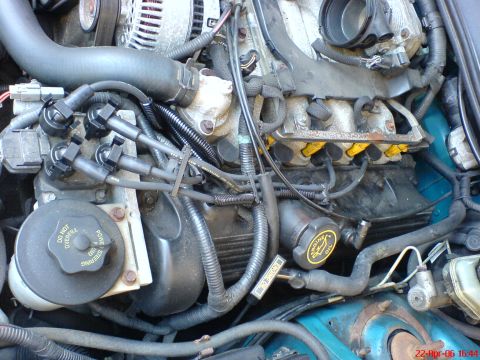 1994 Ford Thunderbird - Close-up view of the engine bay of a 1994 Ford Thunderbird, revealing various components and wiring.