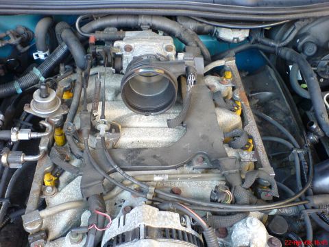 1994 Ford Thunderbird - Engine bay components including throttle body, fuel injectors, and alternator are shown in this close-up view.
