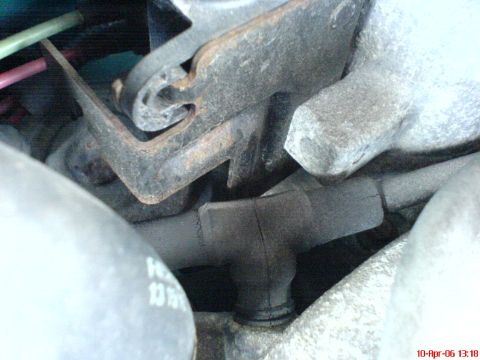 1994 Ford Thunderbird - Close-up view of engine parts, including hoses and metal brackets, with visible signs of wear and rust.