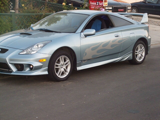 Light blue coupe with silver flame decals on the side and a rear spoiler