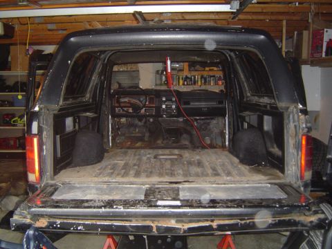 1995 Ford Bronco - The interior of a 1995 Ford Bronco is visible, with the dashboard and cargo area stripped bare.