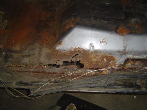1995 Ford Bronco - Significant rust damage is visible on the vehicle's floor pan, with holes and corrosion present.