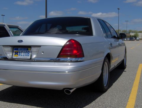 2002 Ford Crown Victoria - A silver 2002 Ford Crown Victoria is parked in a lot, showing its rear and side profile.