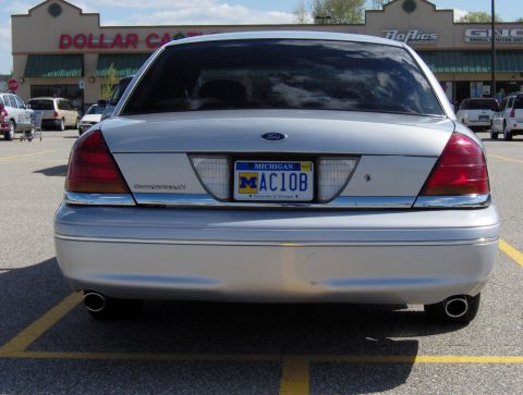 2002 Ford Crown Victoria - The rear of a silver Ford Crown Victoria is shown in a parking lot with a Dollar General store in the background.