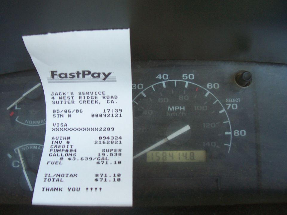Interior view of a speedometer and a FastPay receipt from Jack's Service