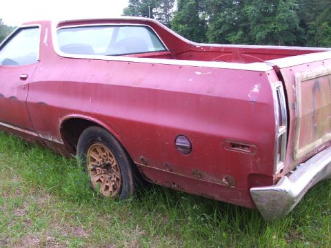1972 Ford Ranchero - Rear view of a red 1972 Ford Ranchero with visible rust on the lower body panels.