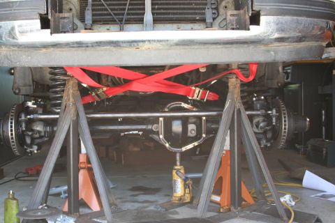 1992 Ford Bronco - Undercarriage view of a 1992 Ford Bronco, showing the front axle and suspension system supported by jack stands.