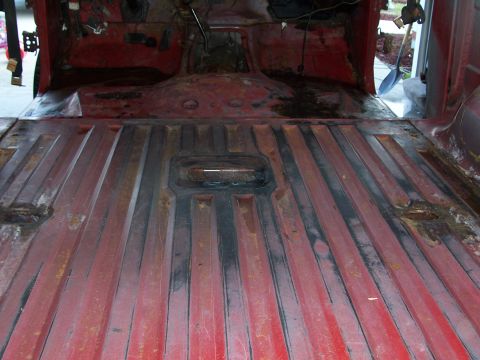 1978 Ford Bronco - The interior of a vehicle displays red ribbed flooring with visible signs of rust and wear, suggesting a need for restoration.