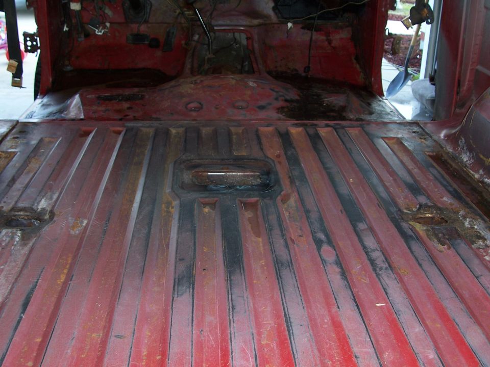 Red ribbed interior flooring of a vehicle, showing rust and wear