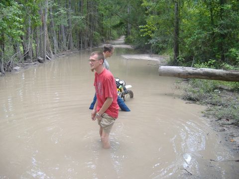 2004 Jeep Wrangler - Two men stand in a flooded dirt path next to a dirt bike.