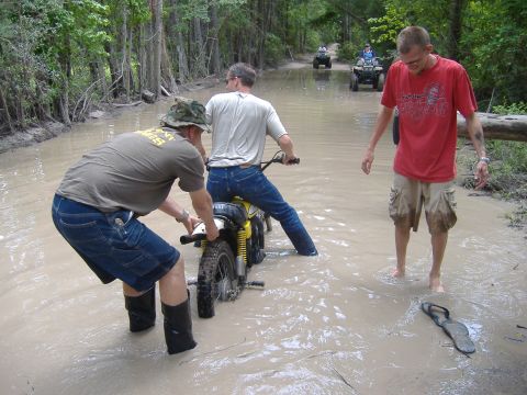 2004 Jeep Wrangler - People navigate a flooded path on dirt bikes and ATVs, with one person helping push a bike.