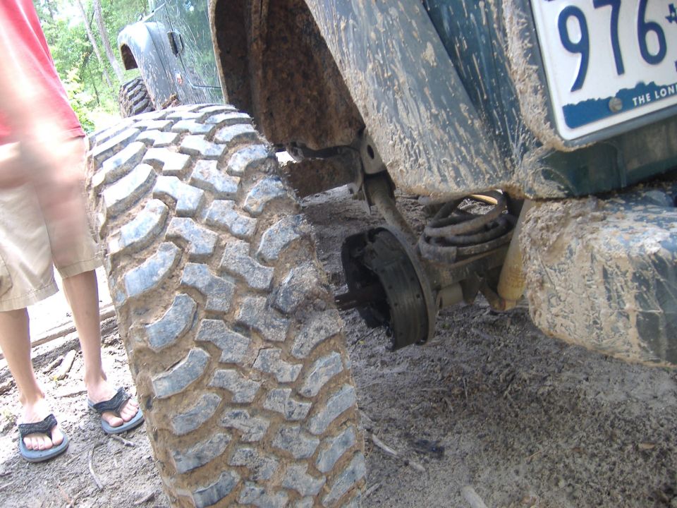 Close-up of a 2004 Jeep TJ's rear tire and suspension, with the axle visible