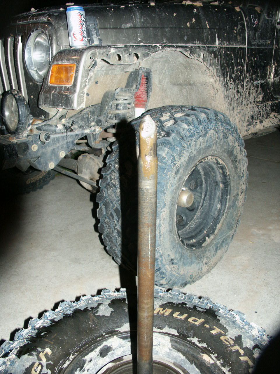 2004 Jeep TJ front axle shaft removed, with tire and wheel nearby