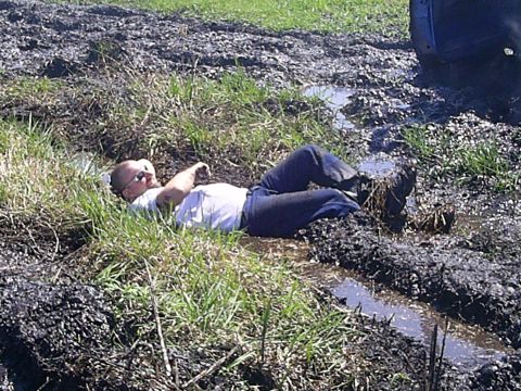 1994 Ford F-250 - A man appears to be enjoying a mud bath next to a vehicle stuck in the mire.