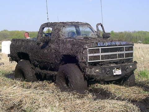 1994 Ford F-250 - This heavily mud-caked pickup truck appears to be stuck in a field, with the phrase 'TEARIN' IT UP' visible on its grille.