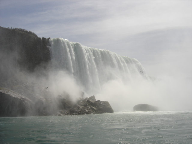 Niagara Falls with mist rising, birds flying, and a Supermotors watermark