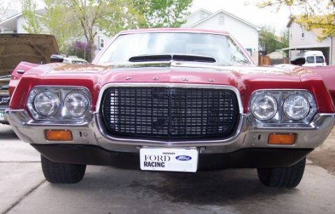 1972 Ford Ranchero - A red 1972 Ford Ranchero is parked in front of another vehicle with its hood up.
