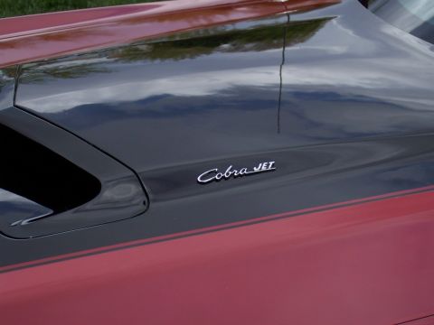 1972 Ford Ranchero - Close-up of a "Cobra JET" emblem on a red and black vehicle.