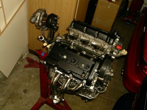 1995 Ford Probe - Engine assembly with turbocharger, mounted on an engine stand in a garage setting.