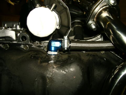 1995 Ford Probe - Close-up of engine components, including an oil filter and braided oil line attached to the oil pan.