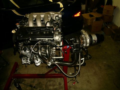 1995 Ford Probe - Engine assembly with turbocharger and custom exhaust manifold on a stand.