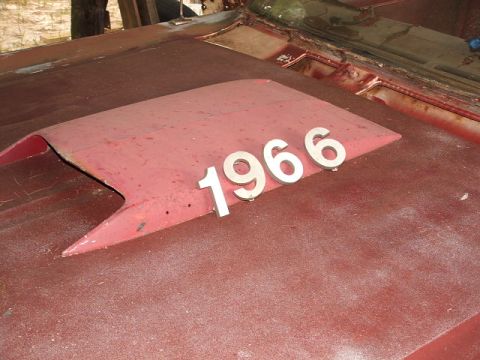 1966 Ford Ranchero - Numbers '1966' are placed on a red hood scoop of a vehicle in disrepair.