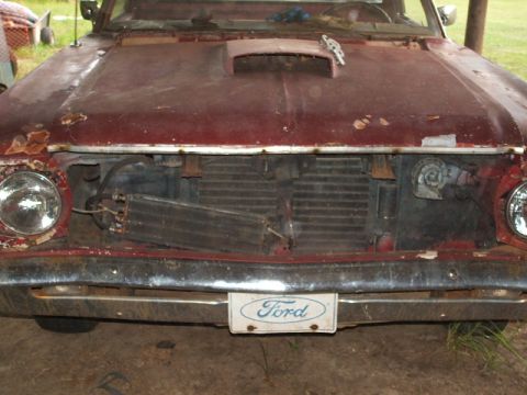 1966 Ford Ranchero - Front view of a 1966 Ford Ranchero showing its damaged grille area and exposed radiator.