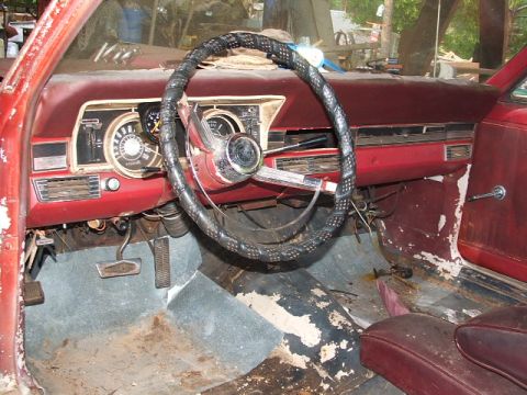 1966 Ford Ranchero - The interior of a classic car shows significant wear and tear, with peeling paint and a dirty floor.