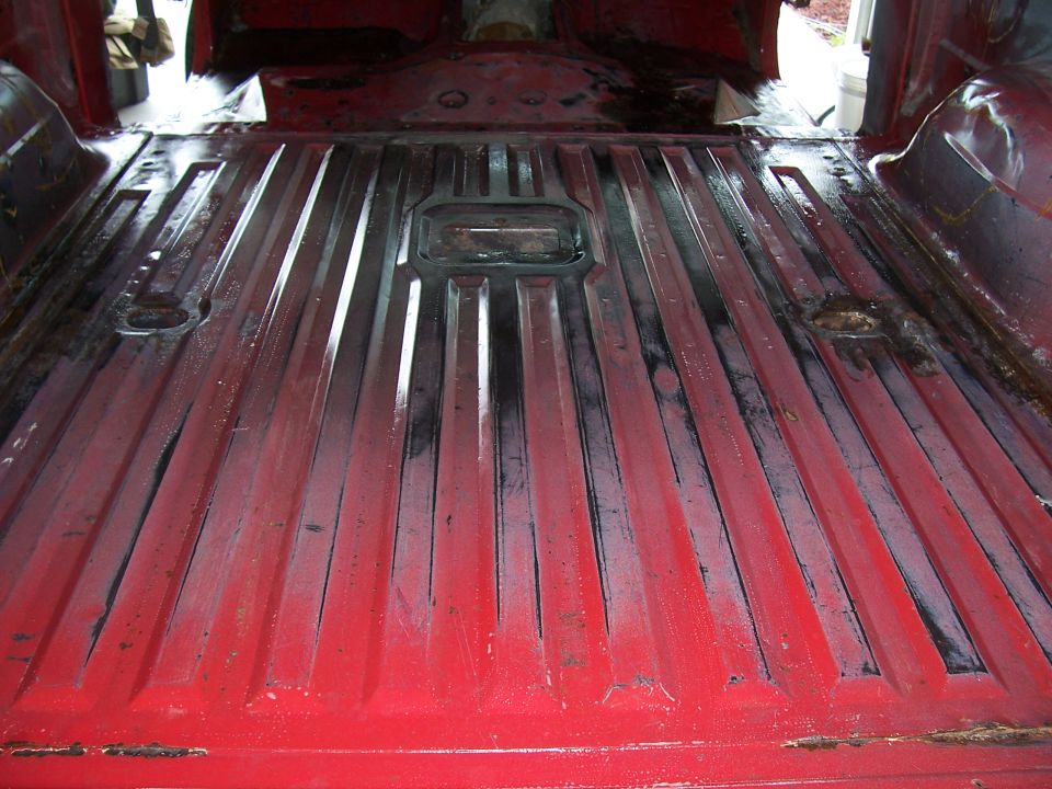 Red truck bed interior with ribbed flooring and tie-down points