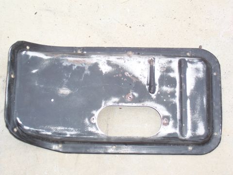 1978 Ford Bronco - A metal part with an oval cutout and mounting holes, exhibiting signs of wear and rust.