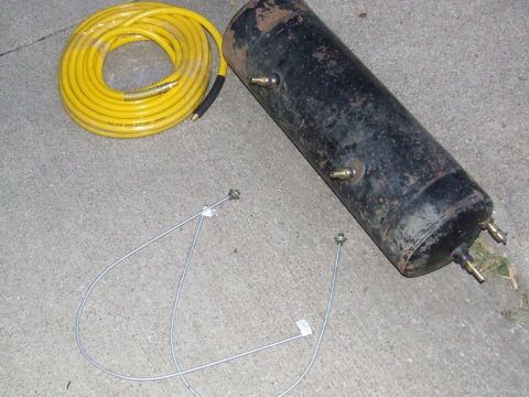 1986 Ford Bronco - An air tank and a coiled yellow hose are shown on a concrete surface.