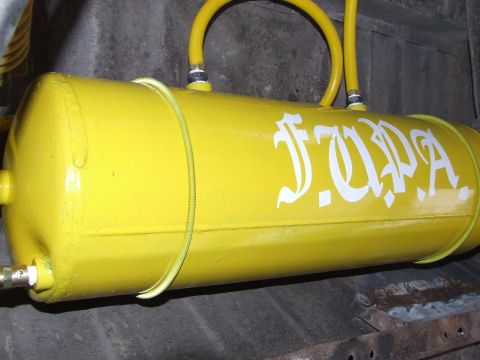 1986 Ford Bronco - A yellow air tank with white lettering is mounted under a vehicle.