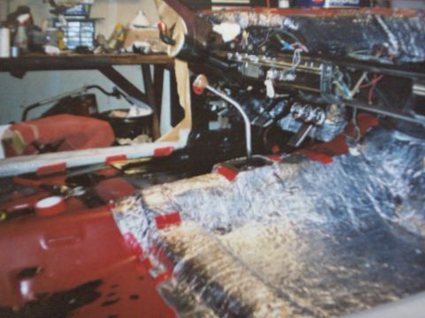 1968 Ford Ranchero - The interior of a vehicle is shown with the dashboard disassembled and sound deadening material being applied to the floor.