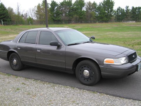 1991 Ford LTD Crown Victoria - This dark gray sedan is a later model Ford Crown Victoria, likely from the 2000s, not a 1991 model.