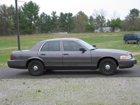 1991 Ford LTD Crown Victoria - Side profile of a gray Ford Crown Victoria sedan with tinted windows.