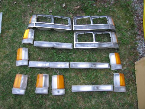 1991 Ford LTD Crown Victoria - Various car headlights and amber turn signal assemblies are displayed on a grassy lawn.