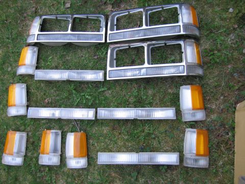 1991 Ford LTD Crown Victoria - Collection of automotive lighting components laid out on a grassy surface.