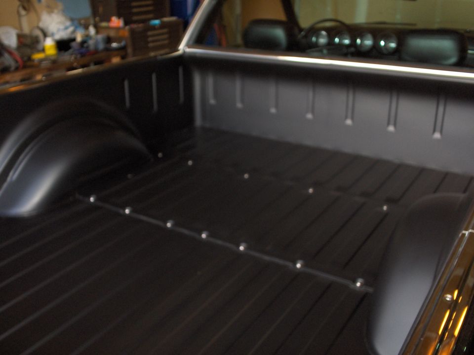 black pickup truck bed with metal strips and tie-down points