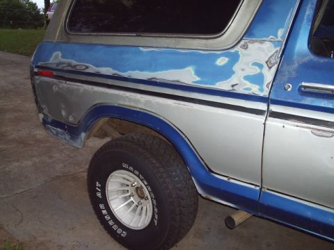 1978 Ford Bronco - The rear quarter panel of the SUV shows areas of primer and exposed metal, indicating bodywork in progress.