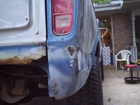 1978 Ford Bronco - The rear quarter panel of a 1978 Ford Bronco shows significant rust and body damage.