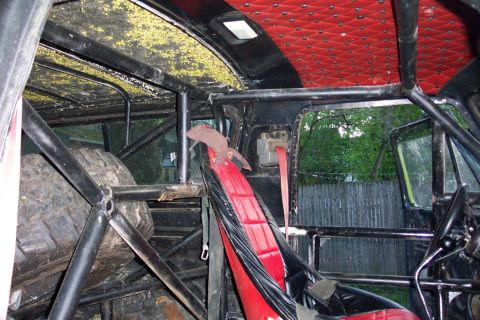1978 Ford Bronco - The interior of this heavily modified vehicle features racing seats, a prominent roll cage, and a spare tire secured within the cabin.