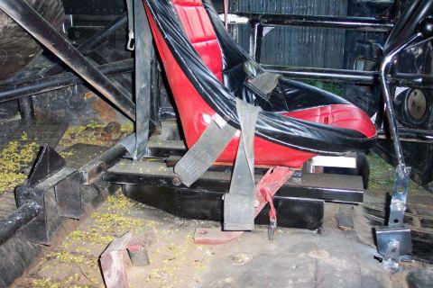 1978 Ford Bronco - Modified vehicle interior shows racing seats and roll cage structure with debris on the floor.