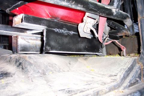 1978 Ford Bronco - Close-up view of the interior seat mounting hardware, showing metal brackets and red padding.